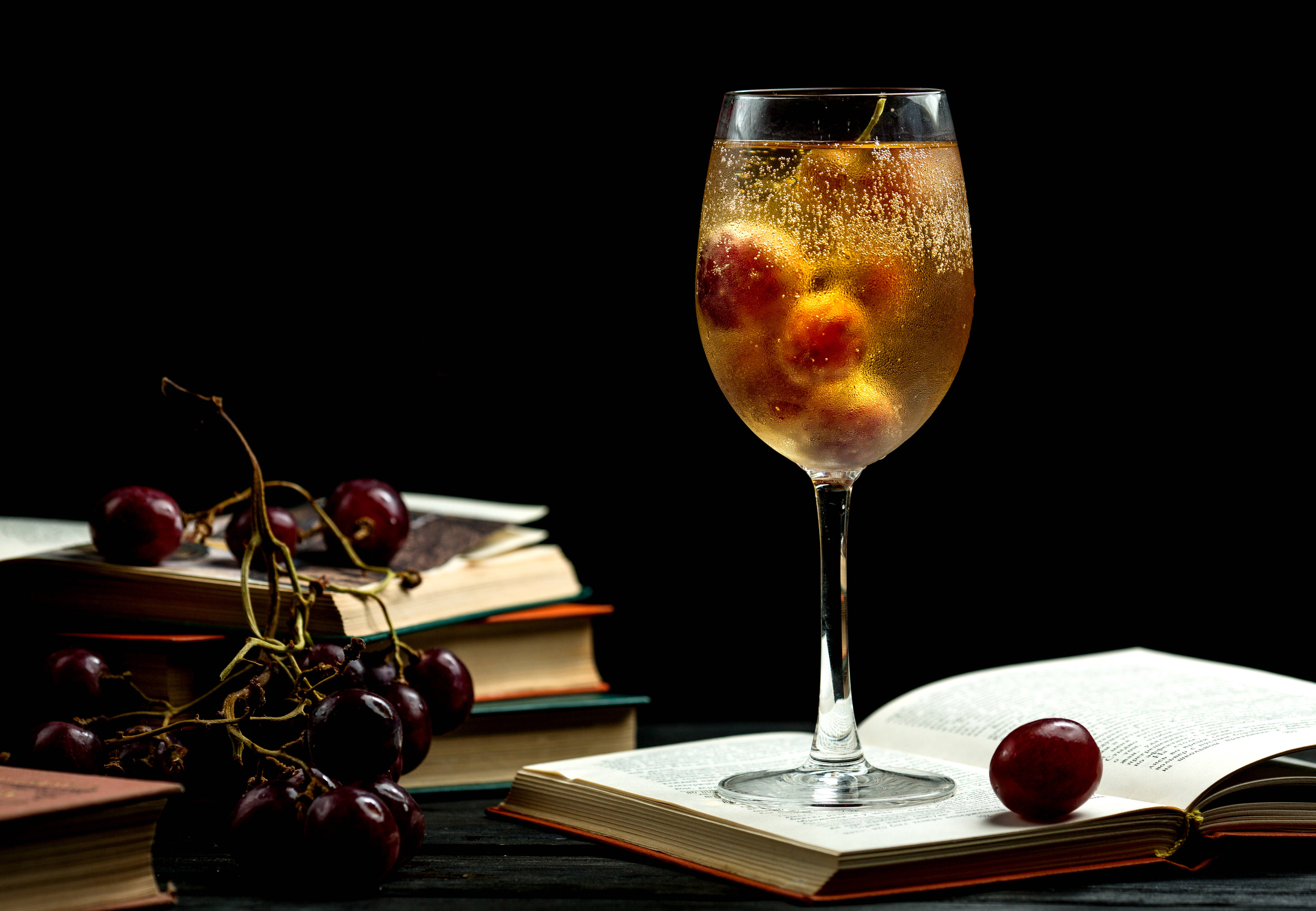 libri e bicchiere di vino con chicchi d'uva