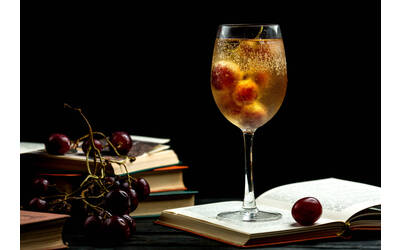 libri e bicchiere di vino con chicchi d'uva