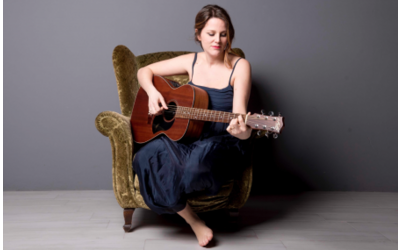 ragazza seduta con chitarra in mano 
