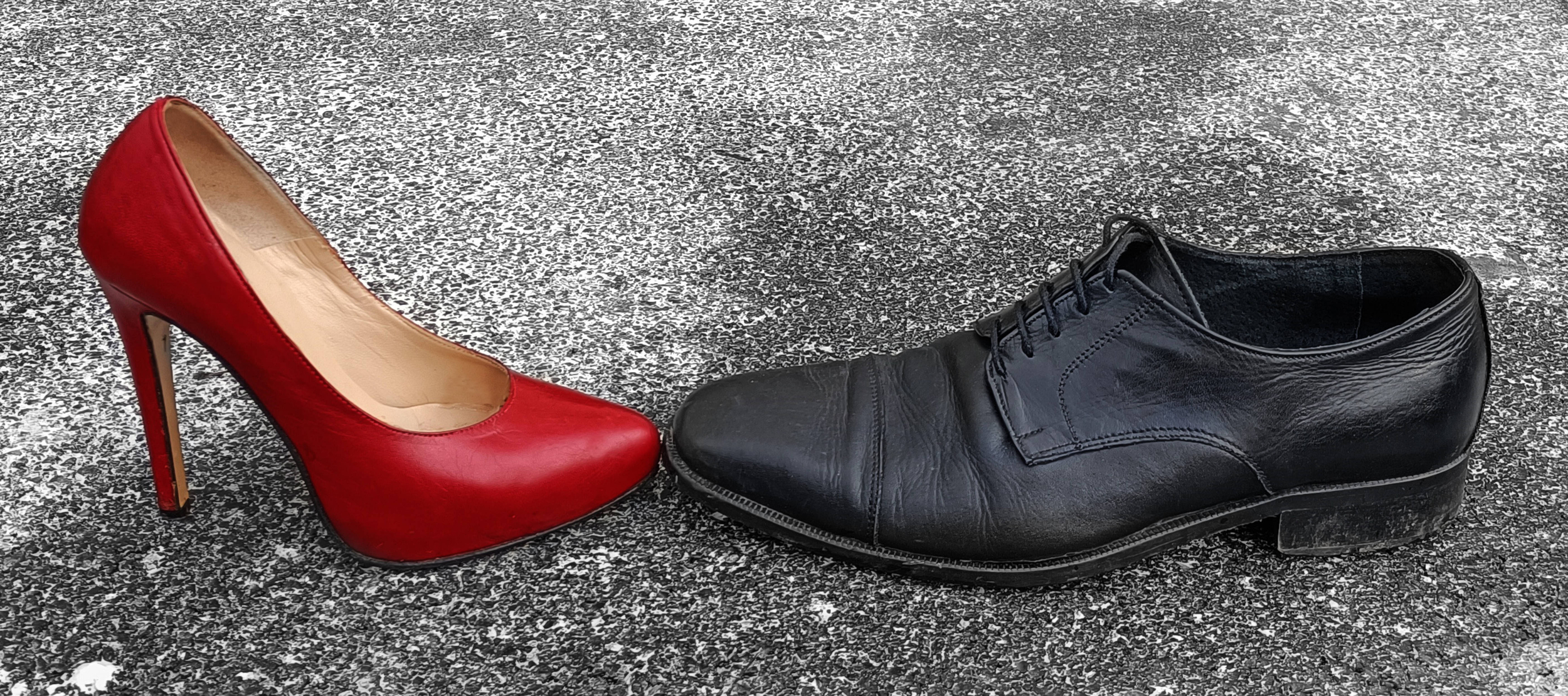Scarpa rossa e nera sull'asfalto una di fronte all'altra