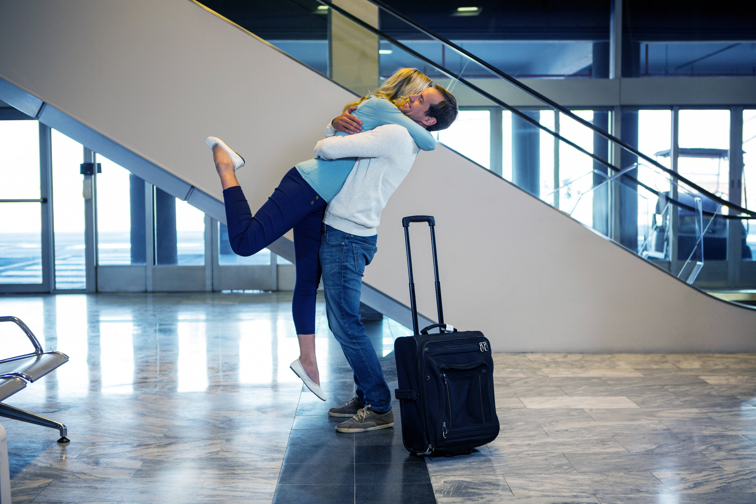 Immagine con due parenti che si abbracciano in aeroporto
