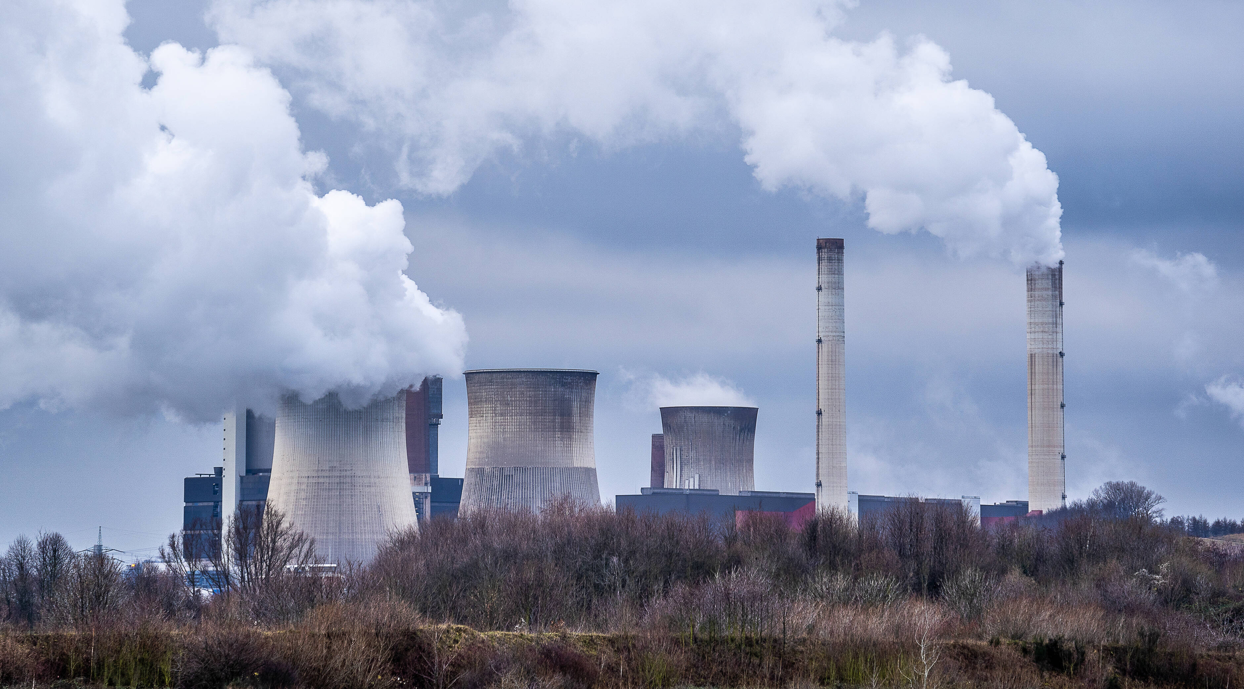 Immagine con industrie che producono fumo