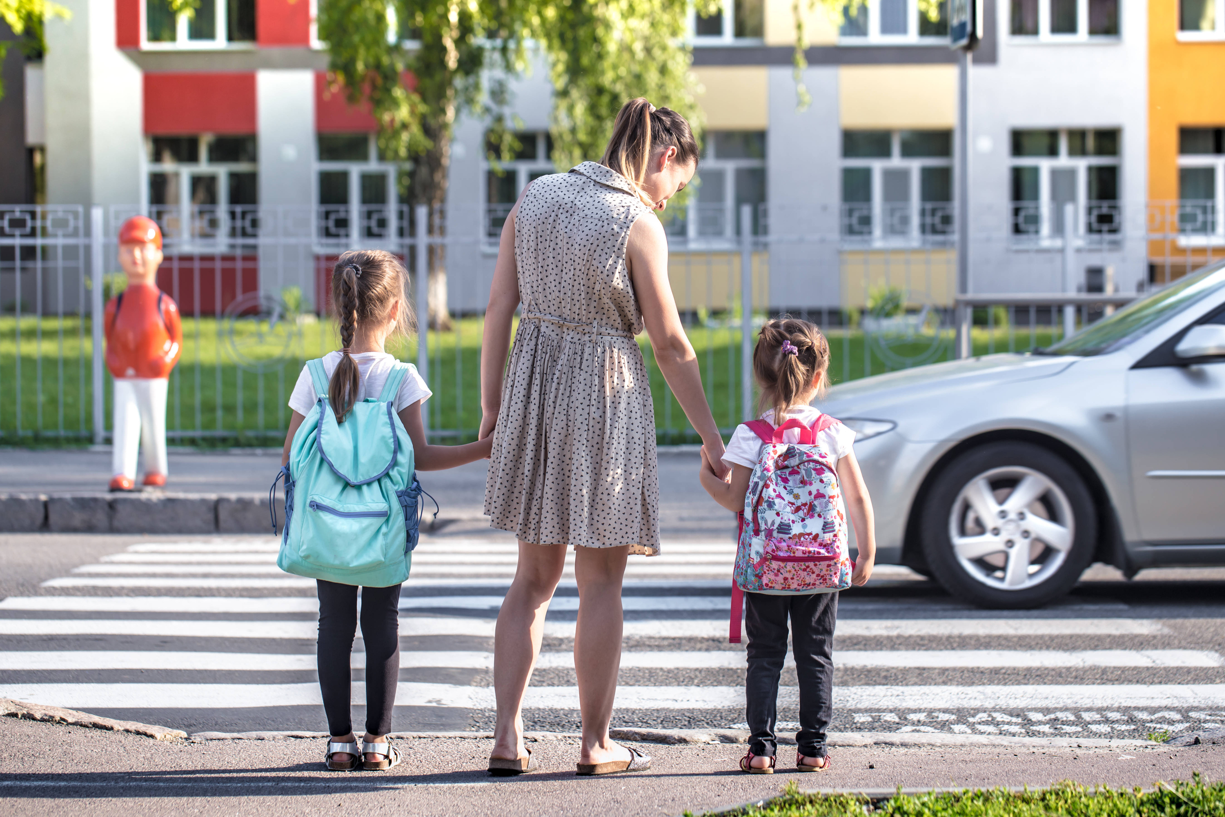 una madre che accompagna le sue figlie a scuola